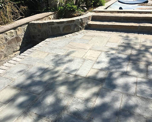 Antique used stone patio with reclaimed cobblestone edging