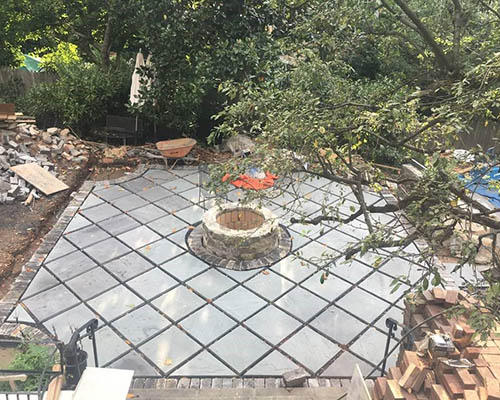 Stone mason set up the installation of backyard patio