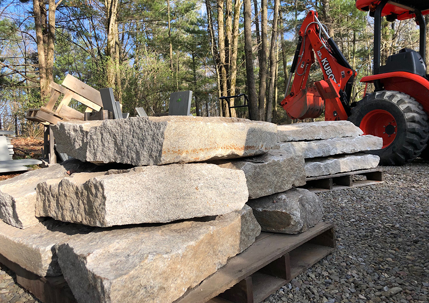 The landscaper breaks up the pieces to spec, preparing the antique stone for installation.