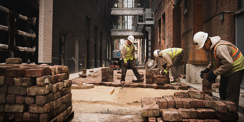 Installers sort through our pallet of used, antique street brick pavers
