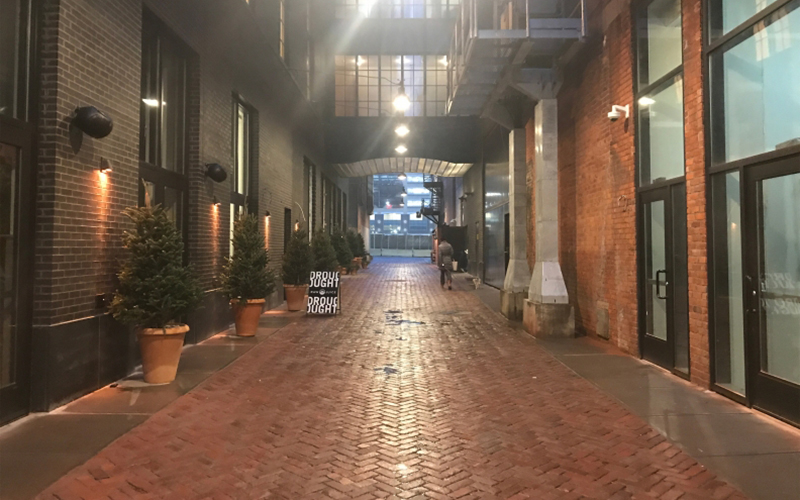 The authentic, century old brick in Parker’s Alley at the Shinola Hotel shines at night