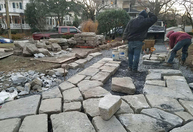 Organizing the salvaged pieces of generation 1 used granite curbing for driveway installation