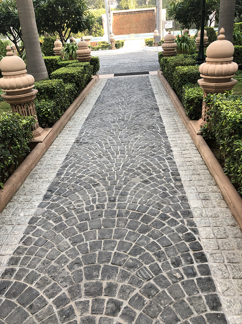 Modern stone path using granite cobbles in a fan pattern. This work is done by hand by skilled masons.