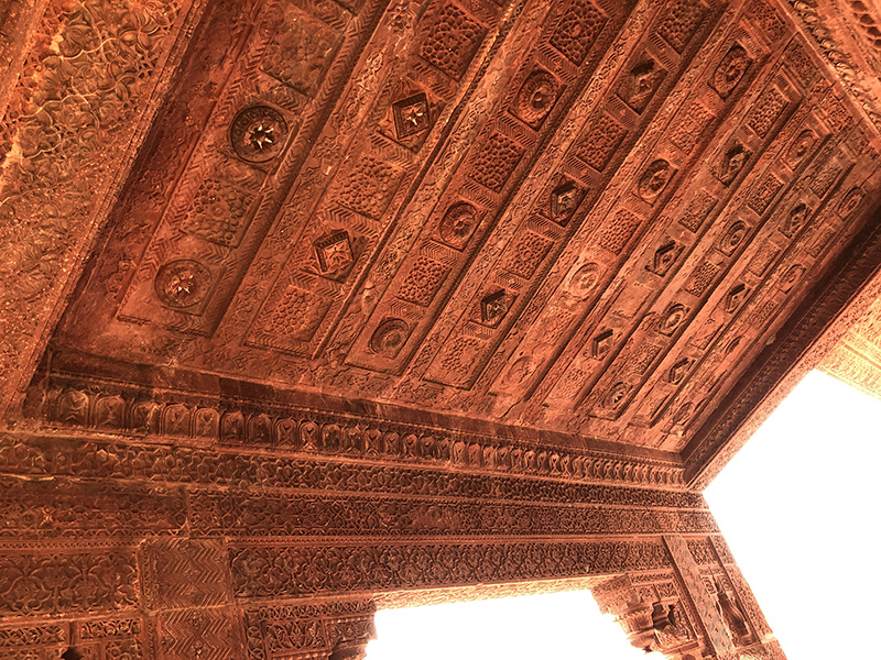 Fine carvings on the underside of a stone awning in the courtyard of a historic palace.