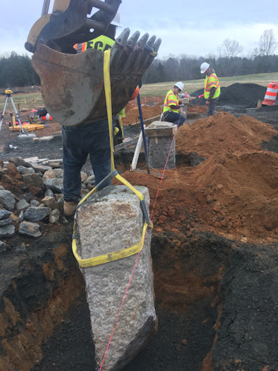 Contractor used machine’s bucket to set stone in place