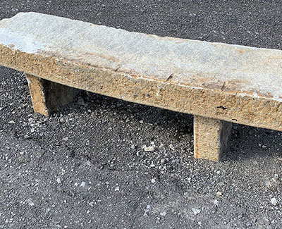 An authentic granite curbing bench is a perfect accent piece for a garden or backyard