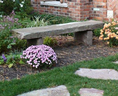 Salvaged, antique stone made bench in landscaping of historic residential estate