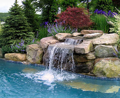 A lake-front home designed a stream over reclaimed stone into their pool